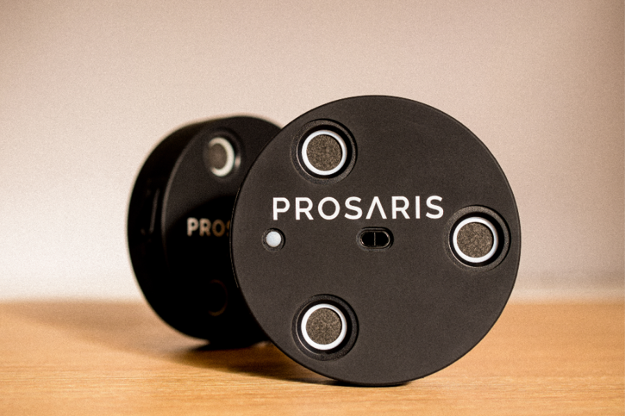 Two PROSARIS ultrasonic sensors are on a wooden table.