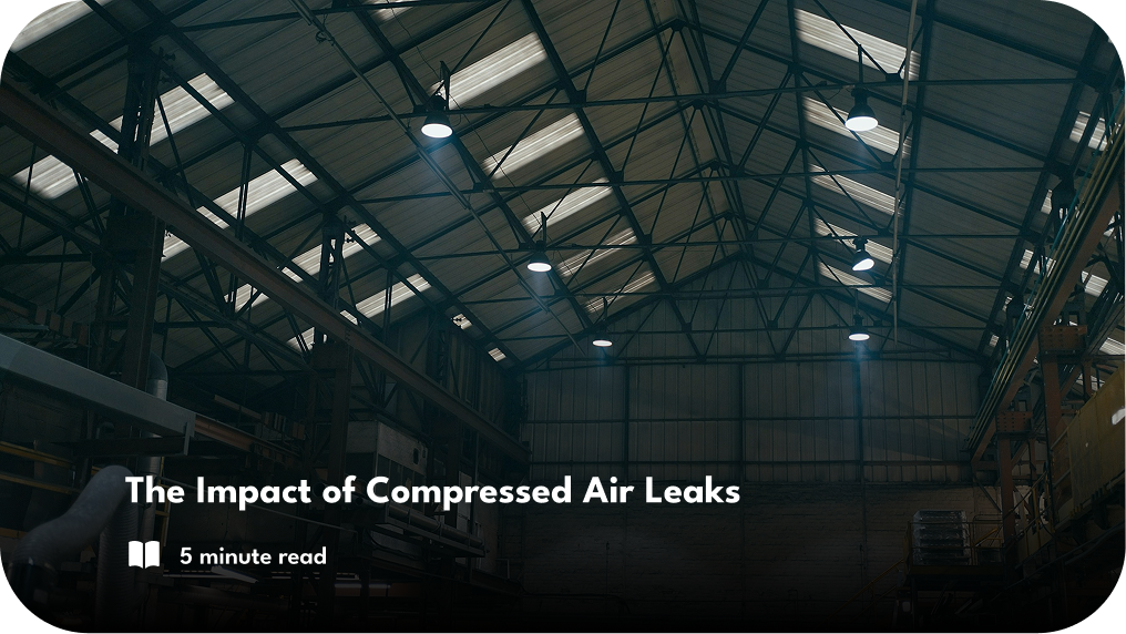 White text is overlaid on top of a warehouse environment. Text reads "The Impact of Compressed Air Leaks. 5 minute read".