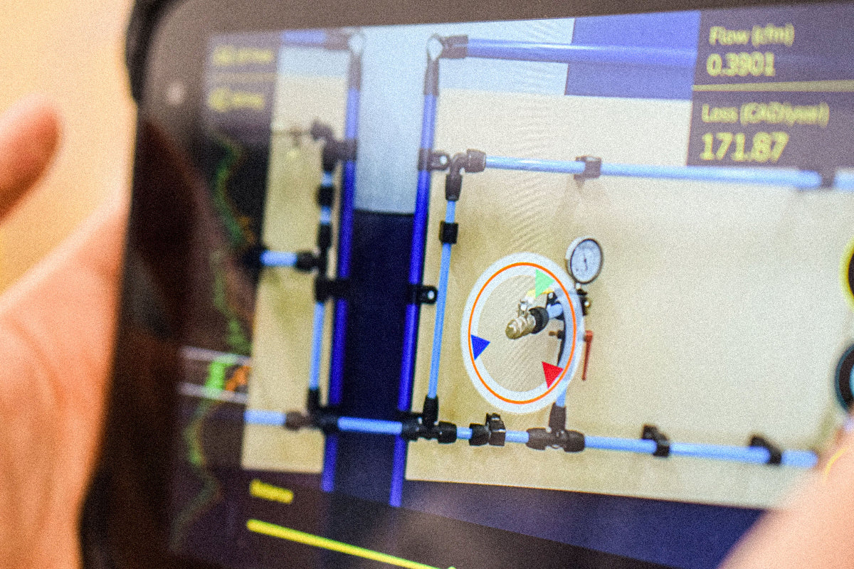 The user interface on the PROSARIS app displays a detected leak, visualized by 3 central arrows.