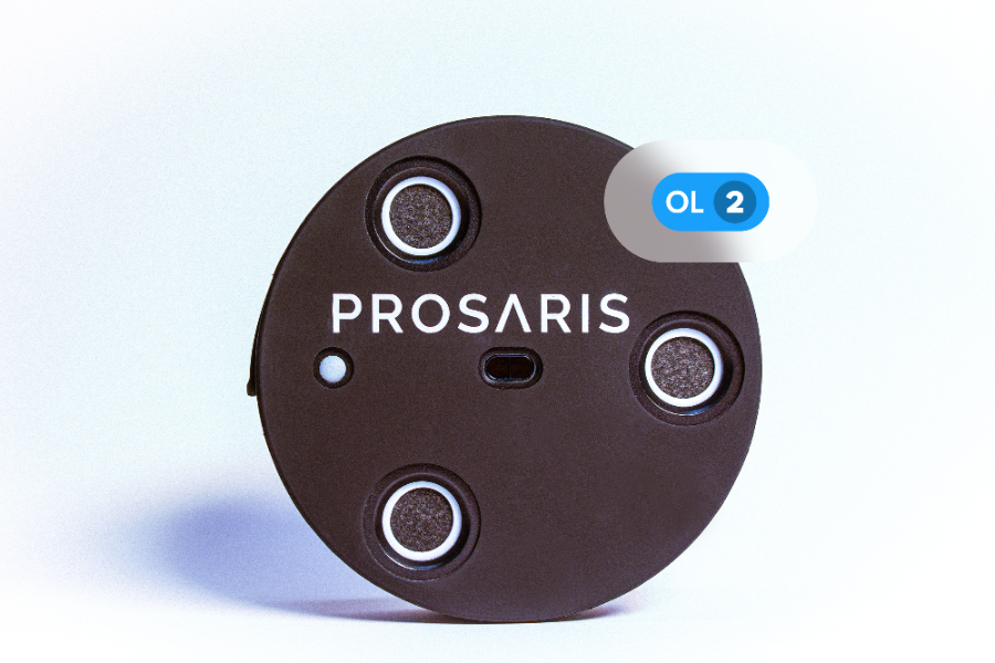 A PROSARIS OL2 ultrasonic device is sitting on a white backdrop. The text "OL2" is overlaid on a blue tag on top of the OL2 device.